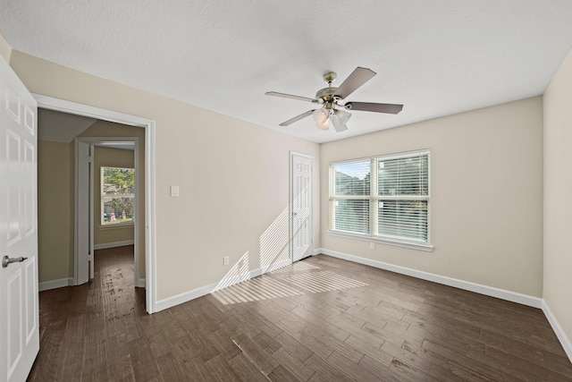 empty room with a textured ceiling, ceiling fan, and dark wood-type flooring