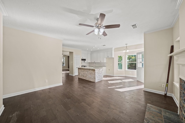 unfurnished living room with dark hardwood / wood-style flooring, ceiling fan with notable chandelier, crown molding, sink, and a tiled fireplace