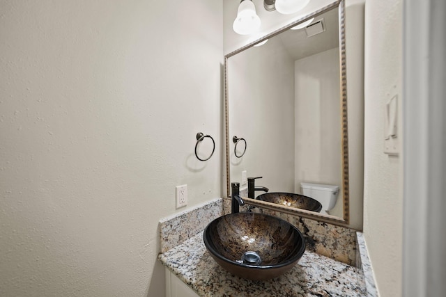 bathroom featuring vanity and toilet