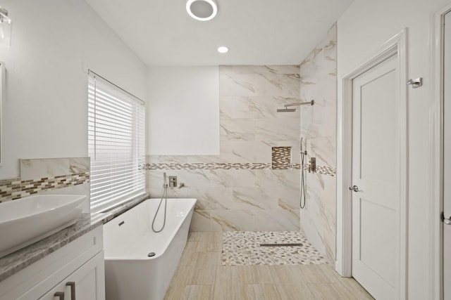 bathroom with vanity, shower with separate bathtub, and tile walls