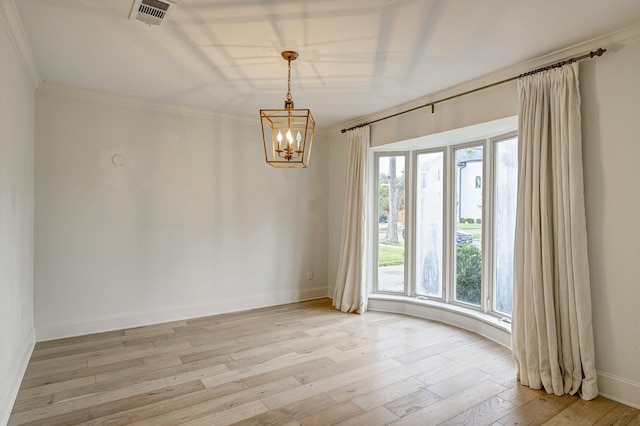 empty room featuring a notable chandelier, light hardwood / wood-style floors, and ornamental molding