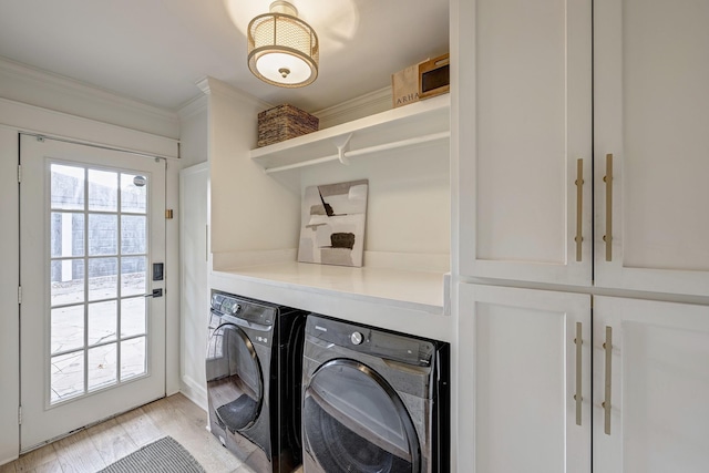 laundry area featuring separate washer and dryer, ornamental molding, cabinets, and light wood-type flooring