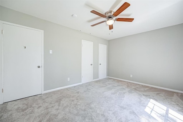 unfurnished bedroom featuring ceiling fan and light colored carpet