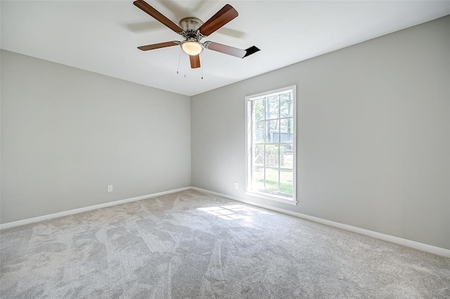 carpeted spare room featuring ceiling fan