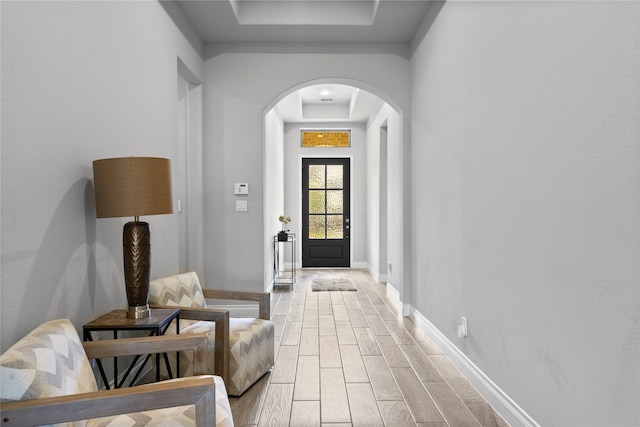 entrance foyer with a raised ceiling and light hardwood / wood-style flooring