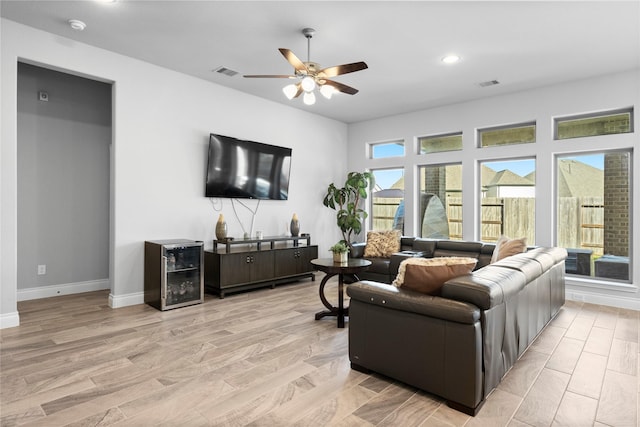 living room featuring light hardwood / wood-style floors, wine cooler, and ceiling fan