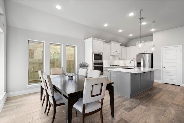 dining space featuring dark hardwood / wood-style flooring, lofted ceiling, and sink