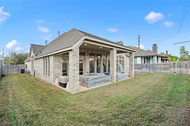 back of house featuring central air condition unit, a yard, and a patio