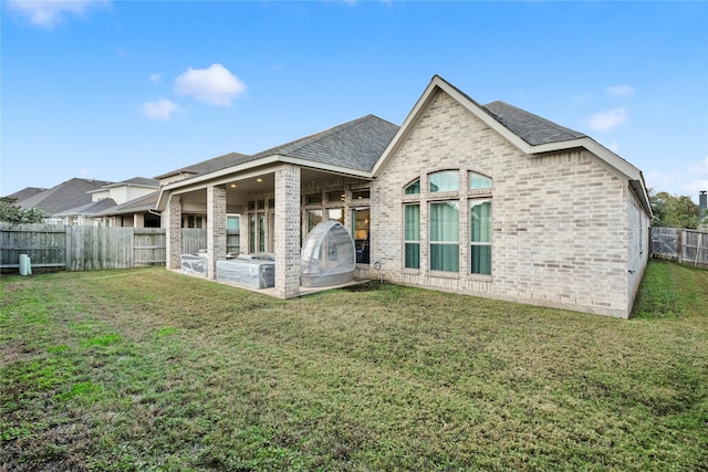 rear view of house with a yard and a patio