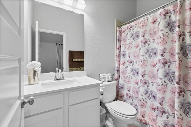 bathroom with vanity, a shower with shower curtain, and toilet