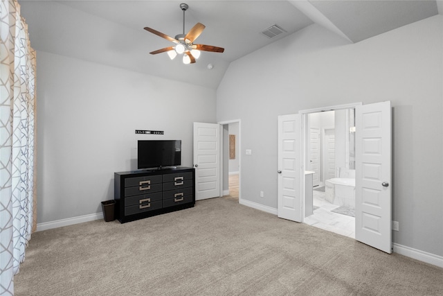 bedroom with ceiling fan, ensuite bathroom, light carpet, and high vaulted ceiling