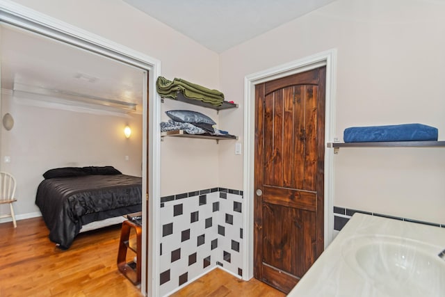 bedroom featuring sink and wood-type flooring