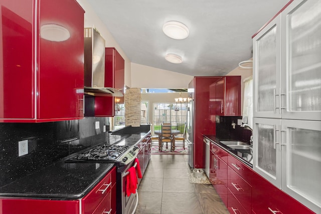 kitchen with appliances with stainless steel finishes, tasteful backsplash, sink, wall chimney range hood, and lofted ceiling