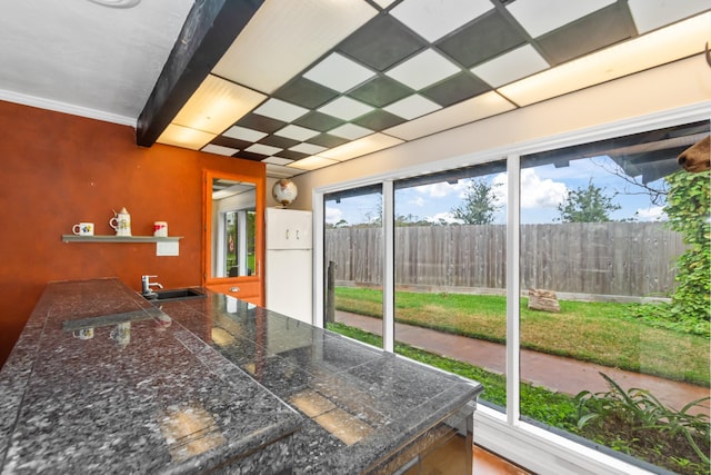 interior space featuring beamed ceiling, white fridge, and sink