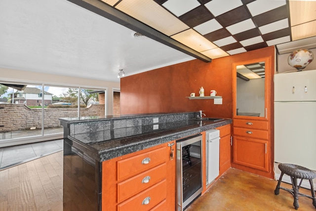 kitchen with sink, white fridge, wine cooler, and dark stone countertops