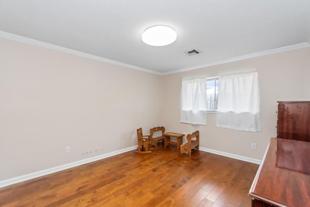 living area with dark hardwood / wood-style flooring and crown molding