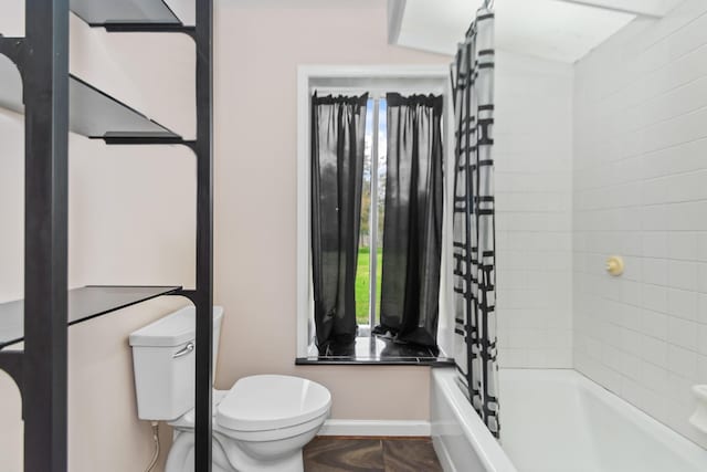 bathroom with shower / bathtub combination with curtain and toilet