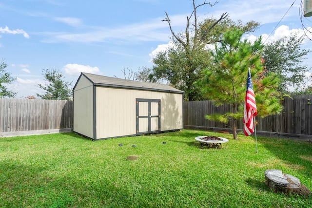 view of yard with a storage shed and an outdoor fire pit