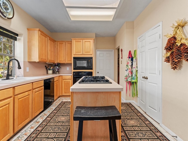 kitchen with a center island, black appliances, light brown cabinets, and sink