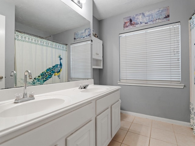 bathroom featuring tile patterned flooring, vanity, and a textured ceiling