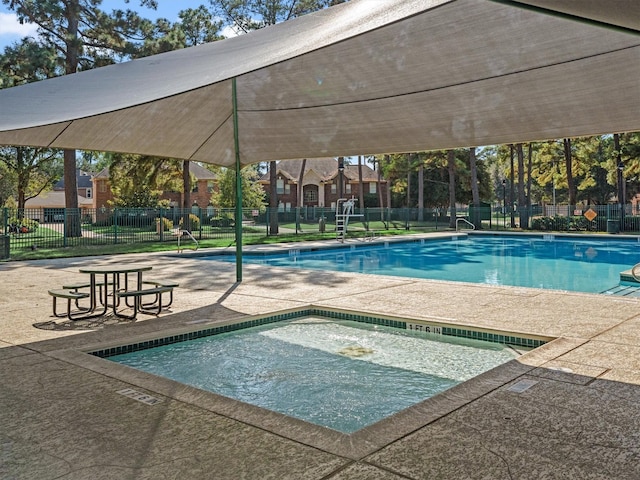 view of swimming pool featuring a hot tub