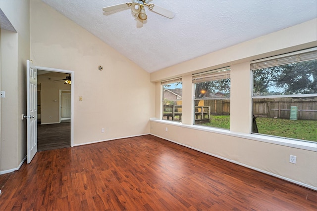 spare room featuring a textured ceiling, ceiling fan, dark wood-type flooring, and high vaulted ceiling