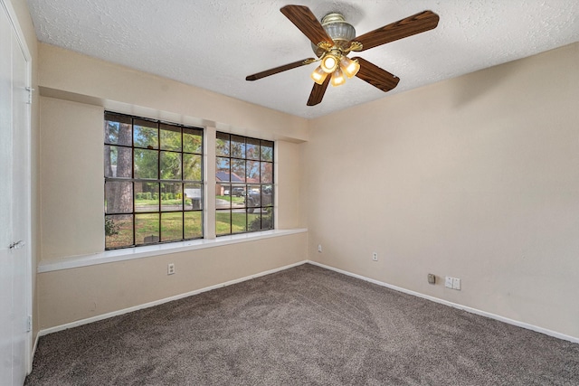 carpeted spare room featuring a textured ceiling and ceiling fan