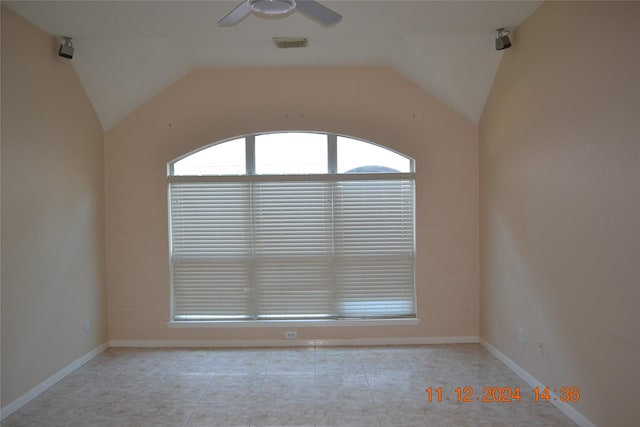 tiled spare room featuring ceiling fan and vaulted ceiling