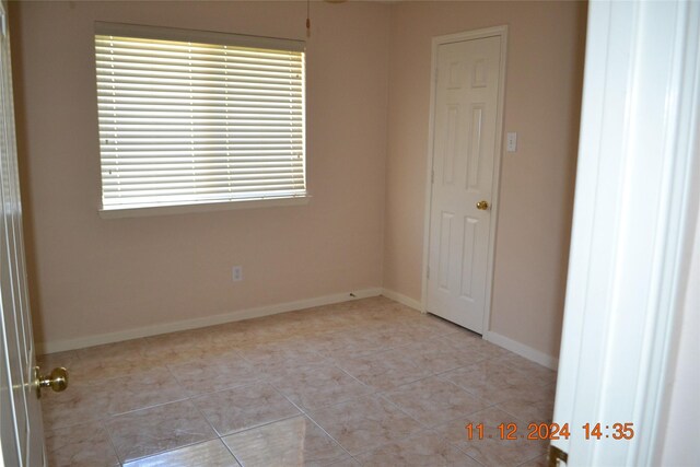 unfurnished room featuring light tile patterned floors