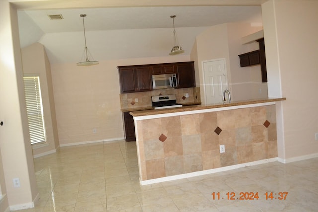 kitchen featuring white stove, kitchen peninsula, hanging light fixtures, light tile patterned floors, and dark brown cabinetry