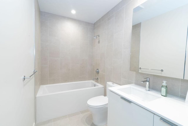 full bathroom with vanity, backsplash, tile patterned floors, tiled shower / bath, and toilet