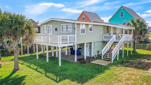 rear view of property with a yard, a patio, and a deck