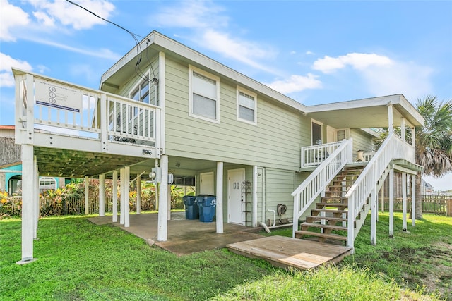 back of property featuring a lawn and a wooden deck