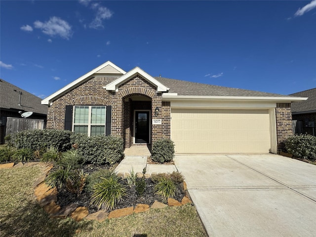 ranch-style home with a garage, brick siding, driveway, and roof with shingles