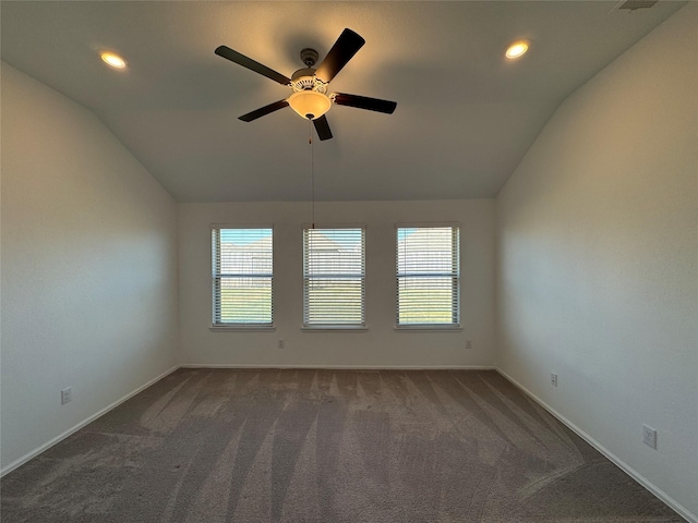 spare room with dark carpet, ceiling fan, and lofted ceiling