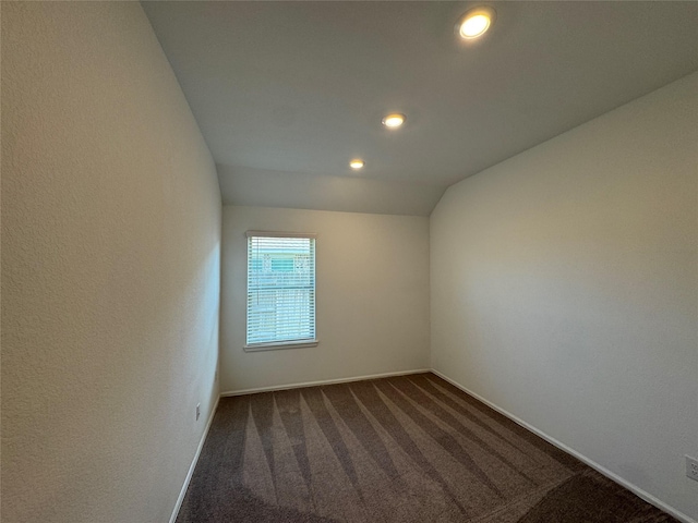 carpeted empty room featuring lofted ceiling