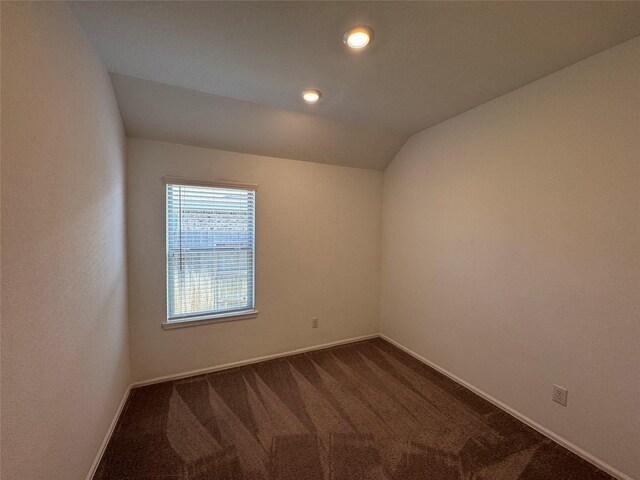 carpeted empty room with vaulted ceiling