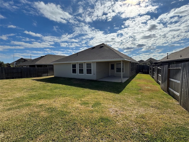 back of house featuring a lawn and a patio area