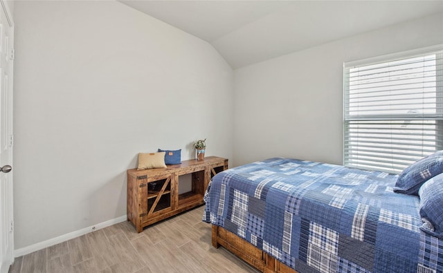 bedroom featuring vaulted ceiling and light hardwood / wood-style flooring