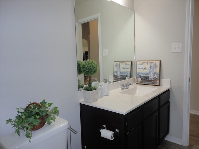 bathroom featuring wood-type flooring, vanity, and toilet