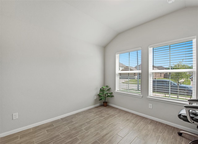 unfurnished office with lofted ceiling and light wood-type flooring