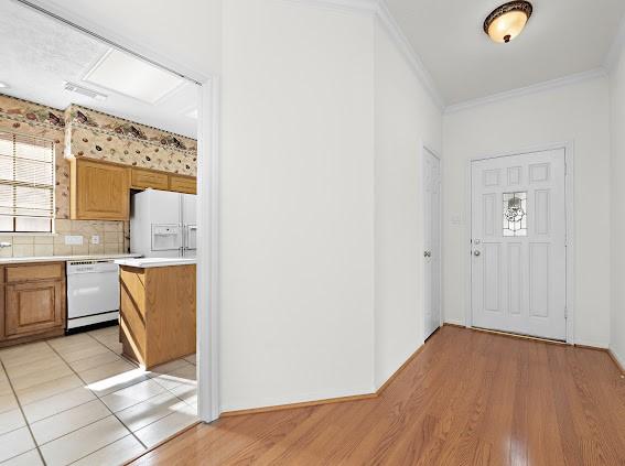 interior space featuring ornamental molding and light wood-type flooring