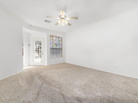 unfurnished room with carpet floors, ornamental molding, and ceiling fan