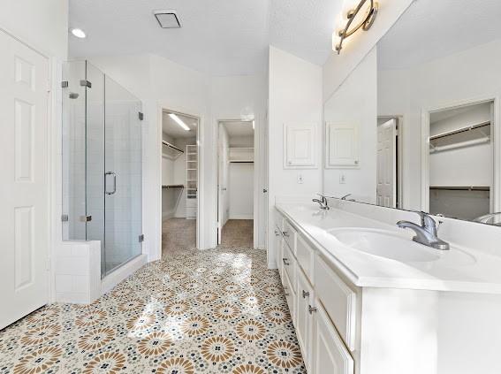 bathroom featuring vanity, tile patterned floors, and a shower with shower door