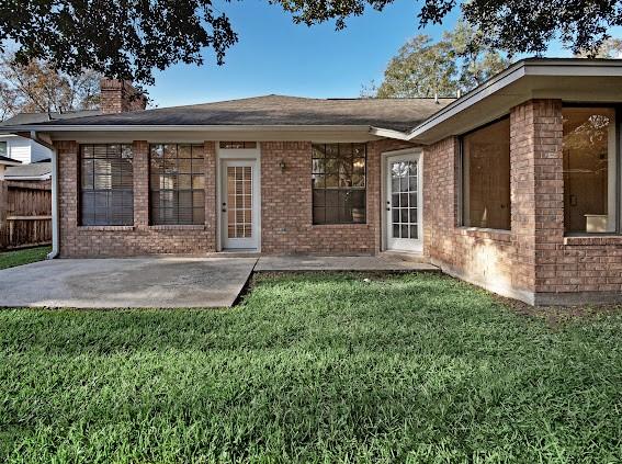 rear view of property with a patio area and a lawn