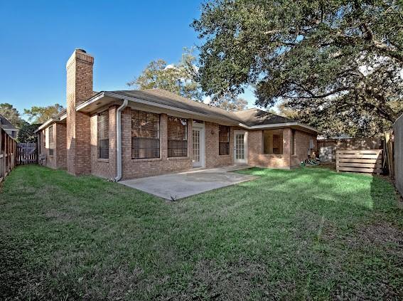 rear view of property featuring a patio area and a lawn