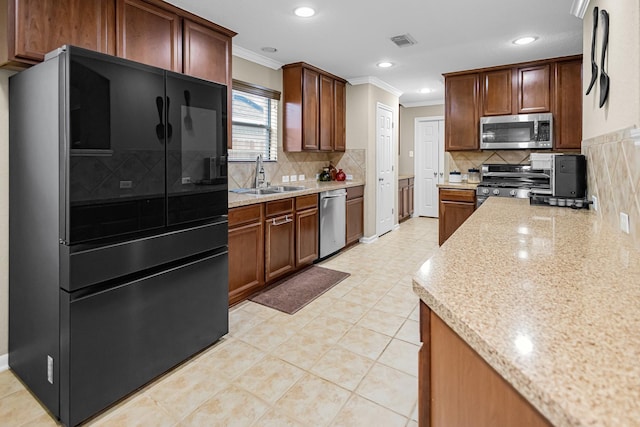 kitchen with appliances with stainless steel finishes, tasteful backsplash, sink, ornamental molding, and light stone counters