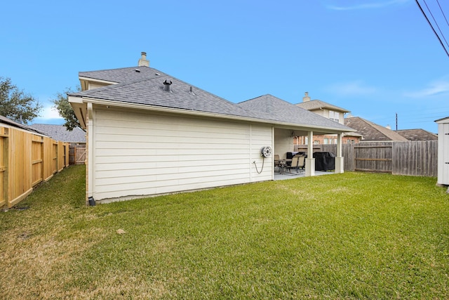 rear view of house featuring a yard and a patio area