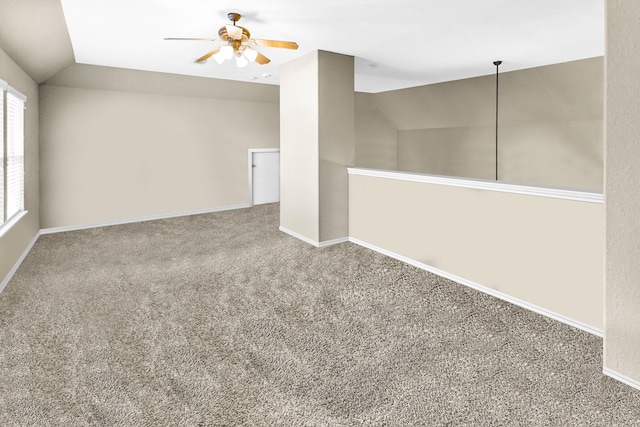 empty room with lofted ceiling, carpet flooring, and ceiling fan