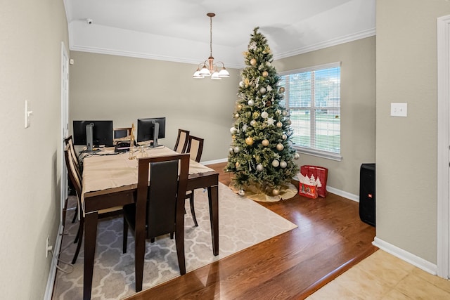 dining area featuring a notable chandelier, crown molding, and hardwood / wood-style floors